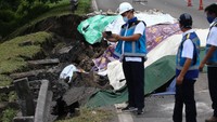 Petugas memeriksa jalan tol yang ambles di ruas tol Surabaya-Gempol KM 06+200, di Surabaya, Jawa Timur, Rabu (27/1/2021). Jalan tol ambles yang terjadi pada Selasa (26/1) yang sebelumnya ditemukan retakan pada Senin (25/1) di lokasi tersebut .