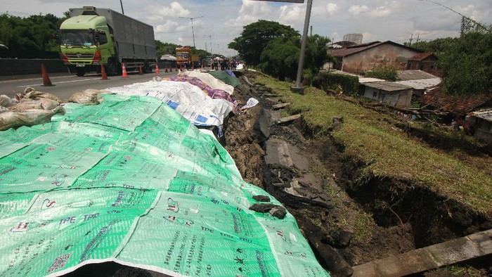 JALAN TOL AMBLES Petugas memeriksa jalan tol yang ambles di ruas tol Surabaya-Gempol KM 06+200, di Surabaya, Jawa Timur, Rabu (27/1/2021). Jalan tol ambles yang terjadi pada Selasa (26/1) yang sebelumnya ditemukan retakan pada Senin (25/1) di lokasi tersebut mengakibatkan kemacetan lalu lintas yang sangat panjang. ANTARA FOTO/Didik Suhartono/hp.