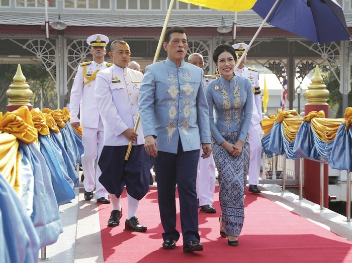 Raja Thailand dan Permaisuri Sineenat Thai King Maha Vajiralongkorn, center, and his royal noble consort Sineenat Wongvajirabhakdi, right, arrive at the Wasukri pier during a merit-making ceremony for her 36th birthday in Bangkok, Thailand, on Tuesday, Jan. 26, 2021. Thai royal noble consort Sineenat was born on Jan. 26, 1985 .(AP Photo)