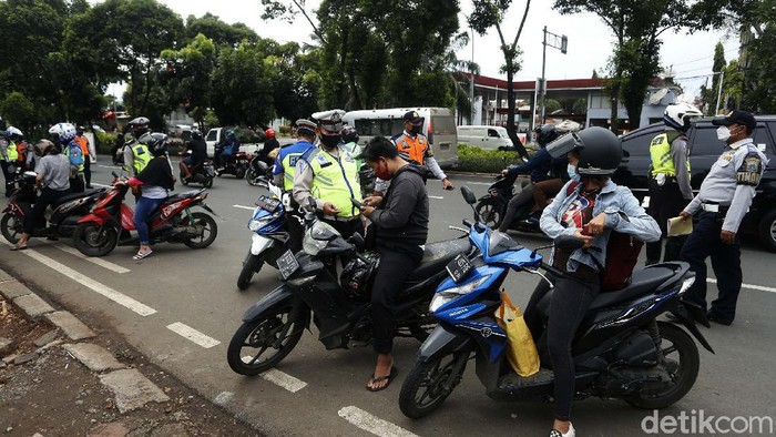 Polisi dan Dishub melakukan razia kendaraan di Jalan Basuki Rahmat, Jakarta Timur, Rabu (27/01/2021). Para pengendara yang tidak memakai helm langsung ditilang.