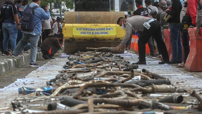 PEMUSNAHAN RIBUAN KNALPOT BLONG Petugas Kepolisian Satlantas Polrestabes Medan menggunakan alat berat disaat memusnahkan barang bukti tangkapan knalpot blong (bising) di Medan, Sumatera Utara, Kamis (28/1/2021). Satuan Lalulintas Polrestabes Medan memusnahkan sedikitnya 2000 knalpot blong hasil operasi tertib lalulintas dari Agustus 2020 hingga Januari 2021. ANTARA FOTO/Rony Muharrman/hp.