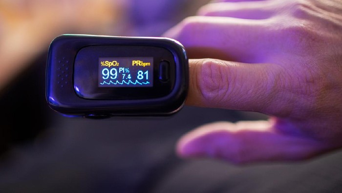 Pulse Oximeter Woman hand introduced in a oximeter to check oxygen levels and pulse because Covid-19 pandemic
