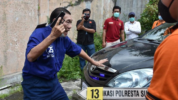 Reka ulang penembakan mobil bos tekstil di Solo. Pelaku tampak mengacungkan pistolnya.