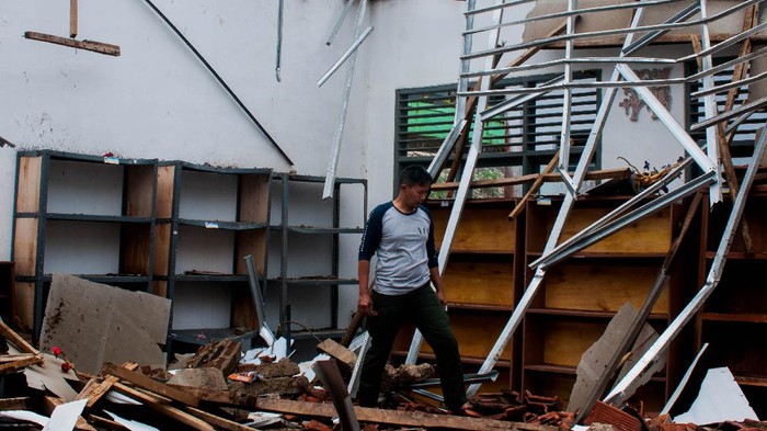 ATAP SEKOLAH AMBRUK DI PANDEGLANG Seorang guru melihat kondisi di sekitar atap bangunan sekolah yang ambruk di SMAN 12 Pandeglang, Banten, Kamis (28/1/2021). Menurut pihak sekolah dua atap ruang biologi dan perpustakaan tersebut ambruk akibat angin kencang disertai hujan deras pada Rabu (27/1/2021) dan menyebabkan kerugian hingga Rp100 juta. ANTARA FOTO/Muhammad Bagus Khoirunas/hp.