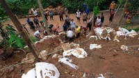 Sejumlah warga bersama relawan menyingkirkan timbunan lumpur dari jalan di lokasi bencana tanah longsor di Desa Jlegong, Bejen, Temanggung, Jawa Tengah, Jumat (29/1/2021).