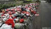 Sampah menumpuk di pinggir Tol JORR Jati Warna, Kota Bekasi, Jumat (29/01/2021).