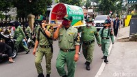 Sejumlah anggota Perlindungan Masyarakat atau Linmas berkeliling kawasan Cimahi, Jawa Barat, sembari menggotong replika keranda mayat, Jumat (29/1/2021).