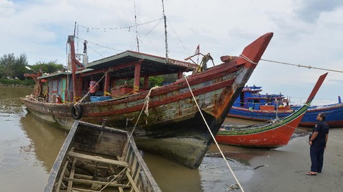 Petugas Pangkalan Pengawasan Sumber Daya Kelautan dan Perikanan (PSDKP) mengamankan satu unit kapal ikan pukat trawl (kiri) pascapenangkapan,  di dermaga Lampulo, Banda Aceh, Aceh, Kamis (28/1/2021). Kapal nelayan lokal, KM Baroena dengan bobot 30 GT itu ditangkap di perairan Aceh Utara dan mengamankan tujuh ABK-nya serta alat tangkap pukat trawl setelah mendapat laporan dari nelayan setempat maraknya terjadi praktek illegal fishing  di perairan Aceh Utara dan perairan Aceh  Timur, provinsi Aceh. ANTARA FOTO/Ampelsa/hp.