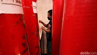 Seorang warga menyalakan lilin di antara lilin-lilin berukuran yang dipersiapkan untuk menyambut Tahun Baru Imlek.