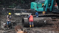 Sejumlah pekeja tampak sibuk menyelesaikan pembangunan. Alat berat pun dikerahkan untuk membantu pembangunan jembatan tersebut.