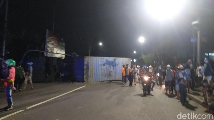 Truk kontainer bermuatan keramik bernopol L 9543 BJ terguling di Jalan Mastrip, Surabaya. Truk tersebut menimpa sebuah mobil dan motor.