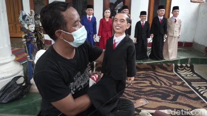 Ujang memperlihatkan wayang golek karakter buatannya..