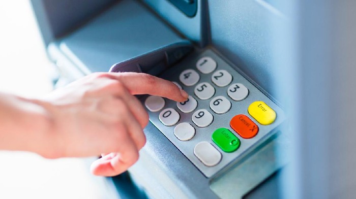 Close-up of hand entering PIN/pass code for a money transfer, on a ATM/bank machine keypad outside