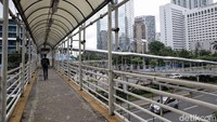 Pejalan kaki menggunakan JPO Karet, Sudirman, Jakarta, Senin (30/1/2021). 