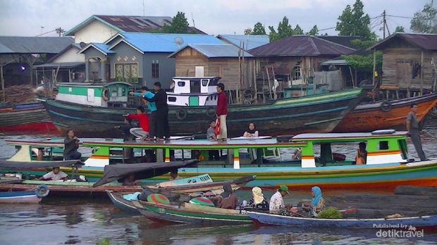 Menanti Pagi di Tepi Sungai Barito Wisatawan berfoto di atas kelotok