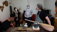 Luthier Ali Akbar Soleimani, kanan, tengah berbincang dengan pelanggan yang memesan alat musik di bengkel kerjanya yang berada di kawasan Tehran, Iran.