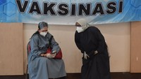 Petugas kesehatan beristirahat di sela-sela pelaksanaan vaksinasi massal di Surabaya, Jawa Timur, Minggu (31/1/2021).