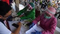 Petugas kesehatan memeriksa kesehatan penerima vaksin COVID-19 saat pelaksanaan vaksinasi massal di Surabaya, Jawa Timur, Minggu (31/1/2021).