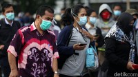 Calon penumpang menerapkan protokol kesehatan dengan memakai masker.