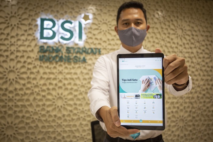 Pegawai menunjukan aplikasi Bank Syariah Indonesia (BSI) usai peresmiannya di Jakarta, Senin (1/2/2021). Presiden Joko Widodo meresmikan BSI yang menandai telah tuntas dan rampungnya proses merger tiga bank syariah milik Himbara yakni PT Bank BRIsyariah Tbk, PT Bank Syariah Mandiri dan PT Bank BNI Syariah. ANTARA FOTO/Dhemas Reviyanto/wsj.