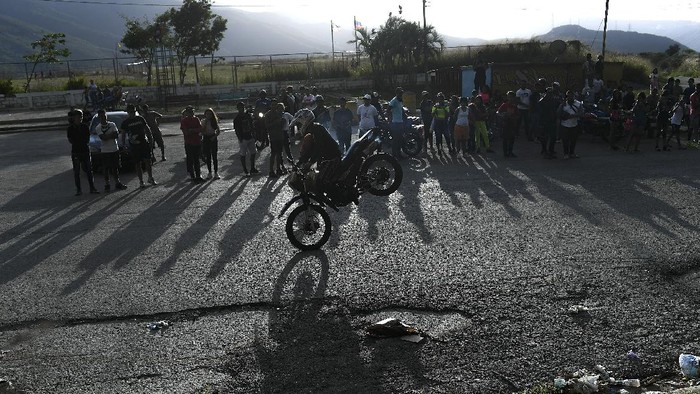 Akrobat Motor, Olahraga yang Lagi Naik Daun di Venezuela Motorcycle stuntman Pedro Aldana performs a wheelie on his motorbike as he rides to an exhibition along the old highway from Caracas to La Guaira, Venezuela, Sunday, Jan. 10, 2021. Aldana, who prefers his show name βCrazy Pedro,