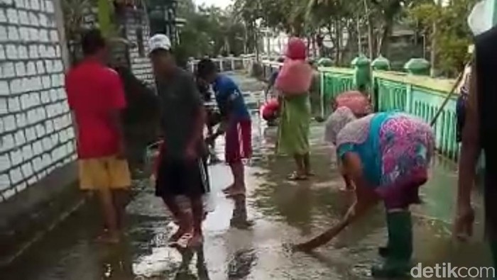 Banjir Mulai Surut, Warga Bersihkan Jalan Berlumut