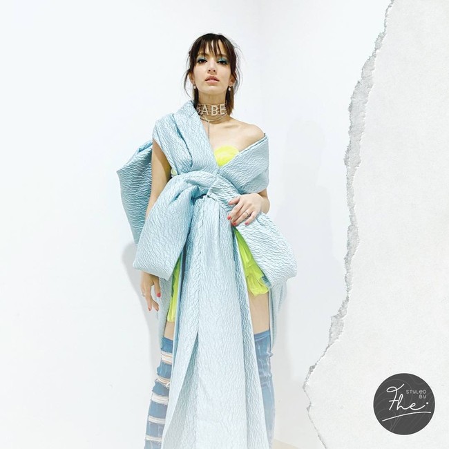 Ingat kejadian Nia Ramadhani dicibir karena aksinya sebagai MC TikTok Awards beberapa waktu lalu? Gaya busananya juga jadi sorotan. Tubuhnya dibungkus dengan gaun pendek berwarna neon, yang kemudian dilapis dengan gaun biru bervolume rancangan Sebastian Gunawan sebagai outer. Gaun tersebut dihiasi pita besar yang menjuntai pada bagian depan. Turut menyempurnakan gayanya, sebuah statement necklace dan sepasang high-knee boots denim. Di Instagram sang stylist, @fherriioo, gaya Nia Ramadhani menimbulkan reaksi yang beragam. This look best, puji seorang netizen. Keren! tulis lainnya. (Foto: Instagram/@fherriioo)