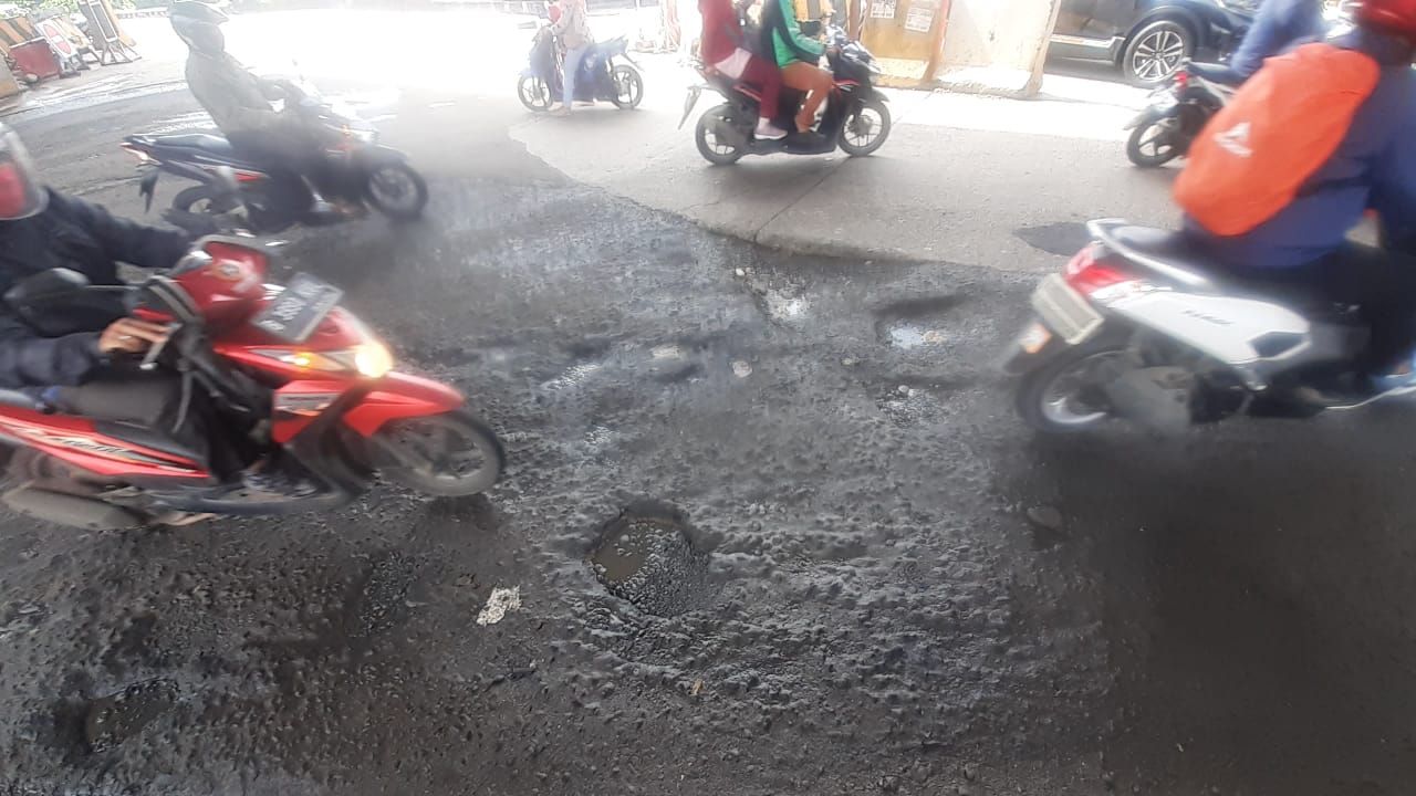 Jalan Rusak  di Jl KH Noer Ali tepatnya di Pertigaan menuju Jalan Caman Raya.