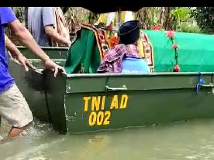 Jenazah seorang wanita warga Kudus dibawa pakai perahu menerobos banjir, Selasa (2/2/2021).