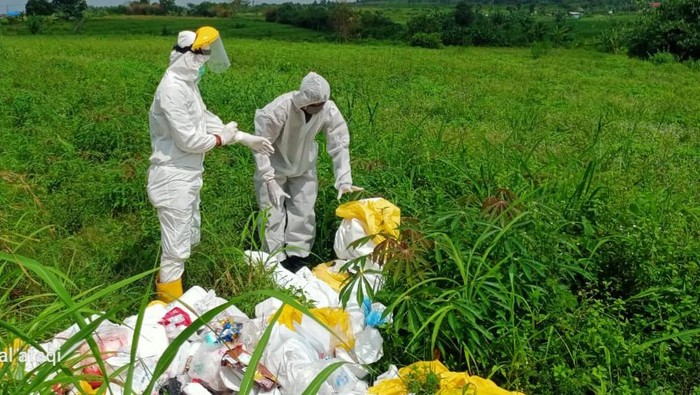 Petugas memeriksa belasan karung sampah medis yang dibuang di lahan kosong, Kabupaten Bogor.
