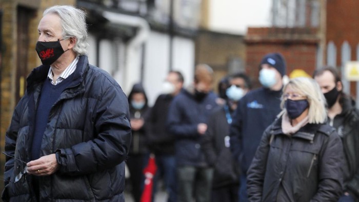 A man takes his own COVID-19 swab test at a newly set-up testing facility in a car park in West Ealing, London, Tuesday, Feb. 2, 2021. British health authorities plan to test tens of thousands of people in a handful of areas of England in an attempt to stop a new variant of the coronavirus first identified in South Africa spreading in the community. The Department of Health says a small number of people in England who had not travelled abroad have tested positive for the strain. (AP Photo/Frank Augstein)
