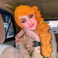 Berawal dari video yang diunggah oleh akun TikTok @yuni_jasminebutiq. Ia tampak memakai seragam PNS dan berpose memperlihatkan gaya hijab kuning menyerupai rambut. Wanita itu juga berdandan dengan riasan full makeup, bulu mata tebal dan blush on. Penampilannya ini pun langsung menuai kritikan karena dianggap berlebihan. Foto: Instagram @yuni_jasminebutiq.