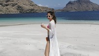 Jalan-jalan di pinggir pantai, tak dilewatkan Nia untuk berpose seksi. Mengenakan outer putih panjang, Nia menikmati segelas minuman dingin. Foto: instagram @ramadhaniabakrie