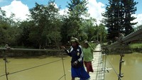 Dua orang wanita menyeberang di Jembatan Wesaput yang melintas Sungai Baliem.