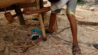 dengan sigap, Pian memalu pasak kayu di beberapa titik badan kapal