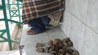 Pria ini mematok tarif Rp. 1000,- untuk tiap batu yang dilempar