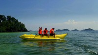 Pengunjung yang sedang menikmati wahana air banana boat di Pantai Melur