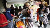 Polisi berkostum wayang juga membagikan masker kepada pedagang pasar.