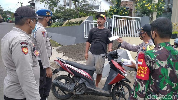 Polisi membagikan masker di Kecamatan Licin, daerah yang mengalami hujan abu dari Gunung Raung. Warga diminta tenang dan waspada saat hujan abu berlangsung.