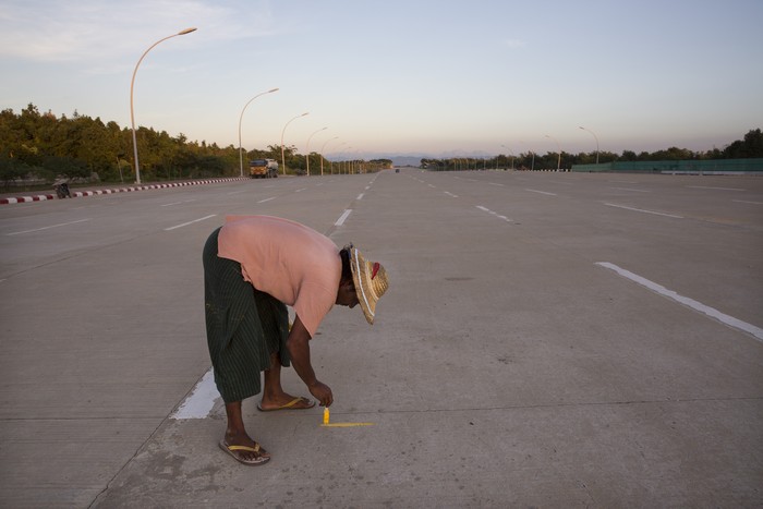 NAYPYIDAW, MYANMAR - NOVEMBER 11:  A Myanmar worker paints a line on the 10 lane road heading to the Parliament building  on November 11, 2014 in Naypyidaw, Myanmar. Myanmars capitol, Naypyidaw, is hosting the 25th Association of Southeast Asian Nations (ASEAN) summit with world leaders including US President Barack Obama, Thai Premier Gen. Prayuth Chan-Ocha, Indonesian President Joko Widodo and Indian Premier Narendra Modi expected to attend. (Photo by Paula Bronstein/Getty Images)