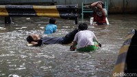 Genangan banjir ini jadi tempat bermain anak-anak.