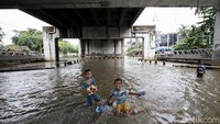 Sejumlah anak bermain banjir di kolong flyover Jatiuwung, Tangerang.