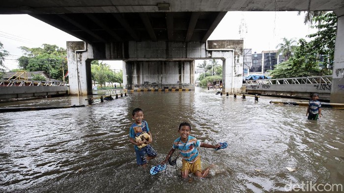 Keseruan Anak-anak Bermain Banjir di Kolong Flyover Jatiuwung Sejumlah anak bermain banjir saat banjir melanda kawasan Jatiuwung, Kota Tangerang, Rabu (3/2/2021).