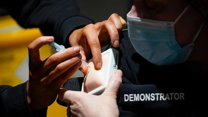 Melihat Pelatihan Relawan Pemberi Vaksin Corona di Inggris MANCHESTER, ENGLAND - JANUARY 30: Volunteers are trained by St John Ambulance instructors to administer Covid-19 vaccines at Manchester United Football Club on January 30, 2021 in Manchester, England. The St John Ambulance volunteer-based organisation is training more than 30,000 volunteers to join the UKs covid-19 vaccination campaign. Volunteer vaccinators complete 21.5 hours of training over four weeks, a blend of online and in-person learning. St John Ambulances highly skilled volunteers have been supporting the NHS throughout the COVID-19 pandemic. (Photo by Christopher Furlong/Getty Images)