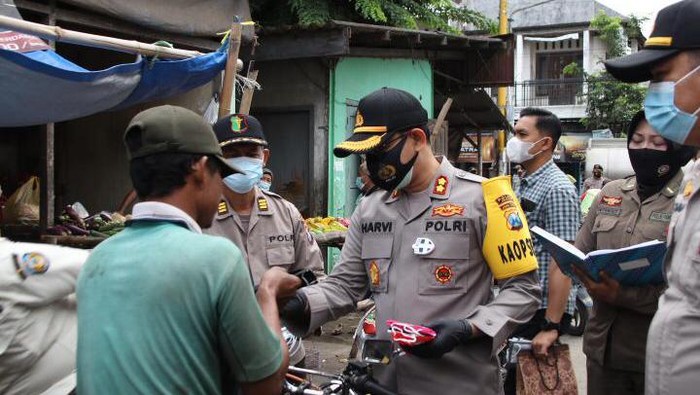 Operasi yustisi di Nganjuk juga diisi dengan pembagian masker. Pembagian masker dilakukan di tiga titik yang sering ditemukan pelanggan prokes.