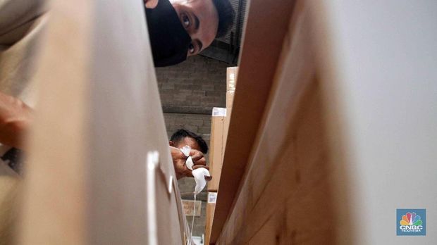 Pekerja menyelesaikan pembuatan peti khusus jenazah COVID-19 di Funisia Perkasa, Kota Tangerang, Banten, Rabu (3/2/2021). Pabrik furnitur tersebut kini memproduksi peti untuk jenazah COVID-19 dan bisa menghasilkan 50 hingga 100 buah peti per harinya. Lonjakan kasus Covid-19 berdampak pada permintaan peti mati. (CNBC Indonesia/ Muhammad Sabki)