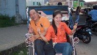 Saya dan istri naik becak di bawah Jembatan Ampera