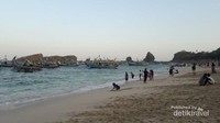Pengunjung bisa bermain pasir, berenang, atau naik kapal nelayan
