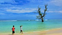 Anak-anak memancing menggunakan tali senar di tepi Pantai Lhok Mee