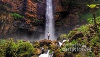 Berfoto di depan air terjun